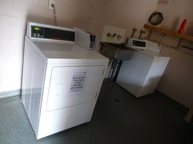 とても簡易な業務用と思われる洗濯機（奥）と乾燥機